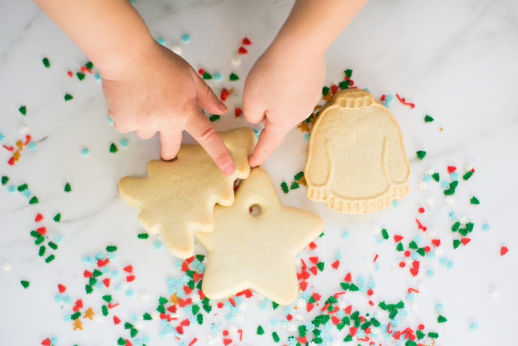 Photo of kids playing with Christmas cookies. 