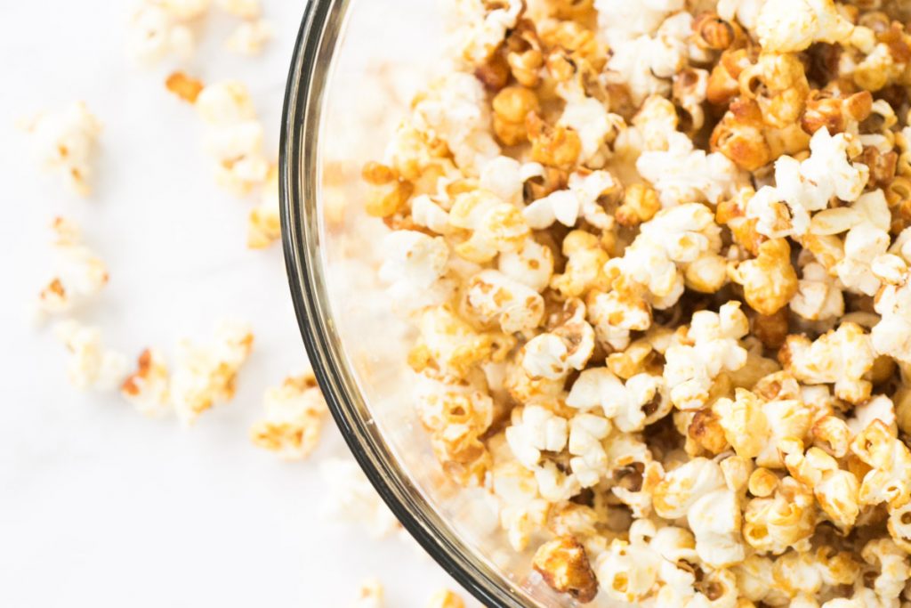 bowl of old fashioned sweet and salty popcorn with popcorn spilling around edges