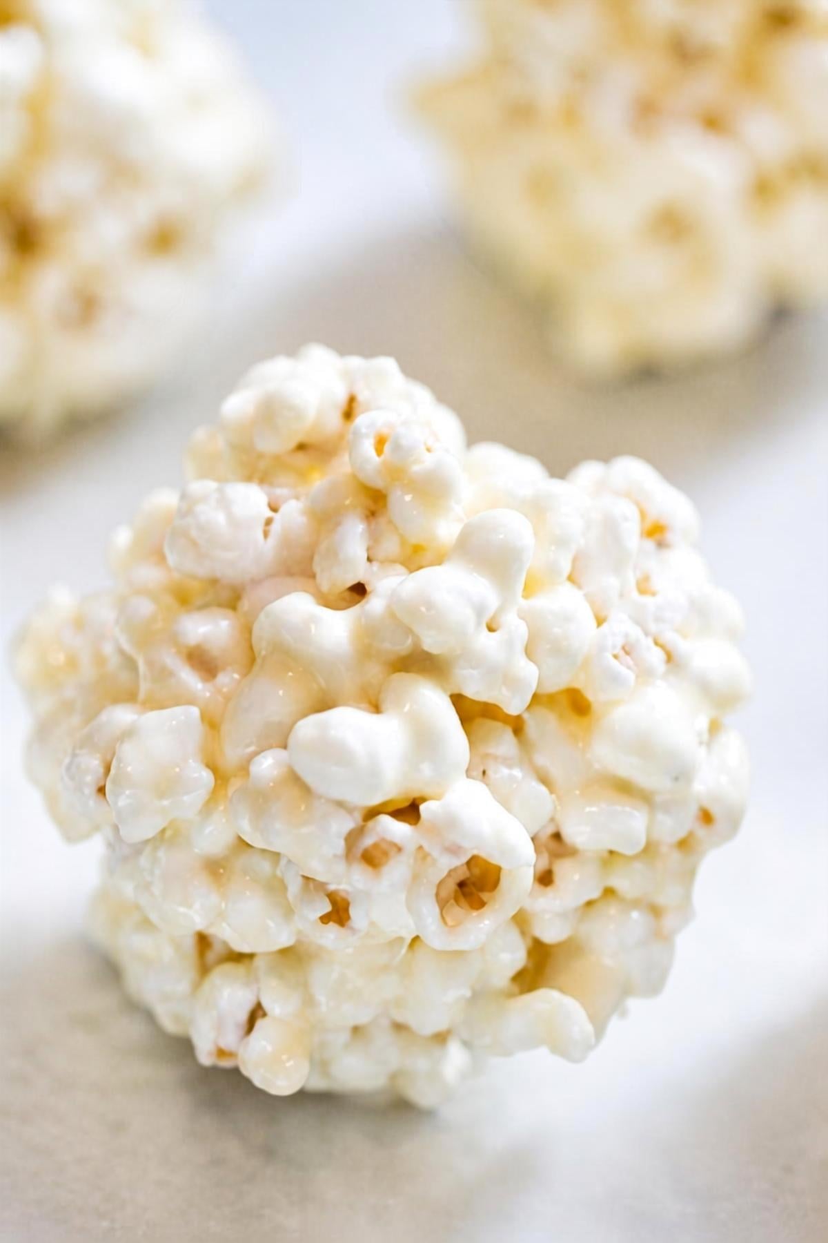 3 ingredient popcorn balls made without corn syrup on a table.