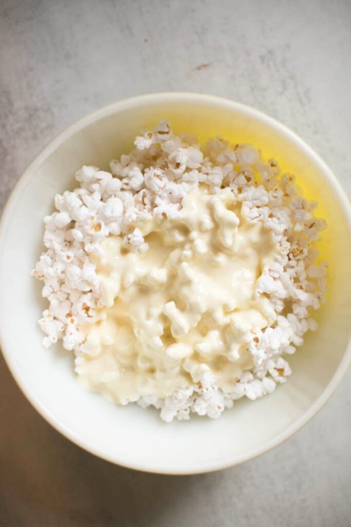 Popped popcorn in a bowl covered with melted marshmallows and butter.