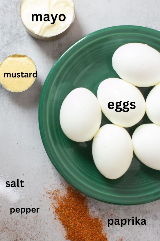 ingredients for deviled eggs; hard boiled eggs, mustard, mayo, slat, pepper, and paprika
