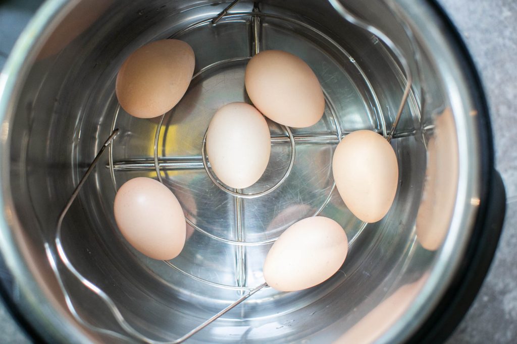 six eggs being hard boiled in an instant pot using the 5-5-5 method.