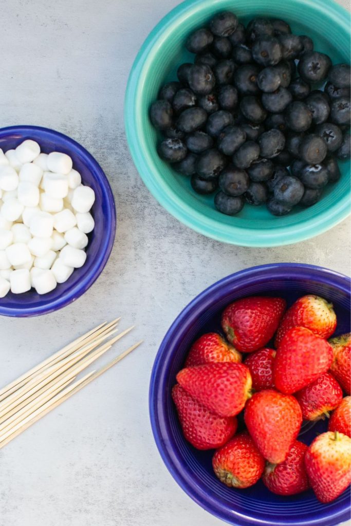 ingredients for patriotic fruit skewers: mini marshmallows, blueberries, strawberries and skewers