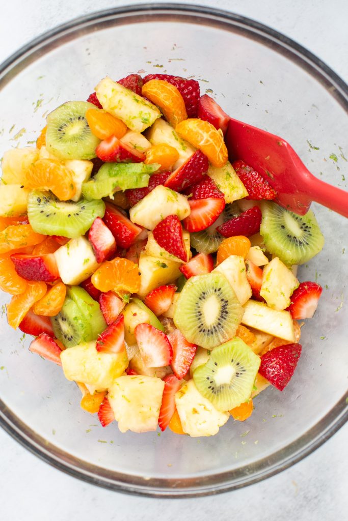 tropical fruit salad ingredients mixed together with honey and lemon juice