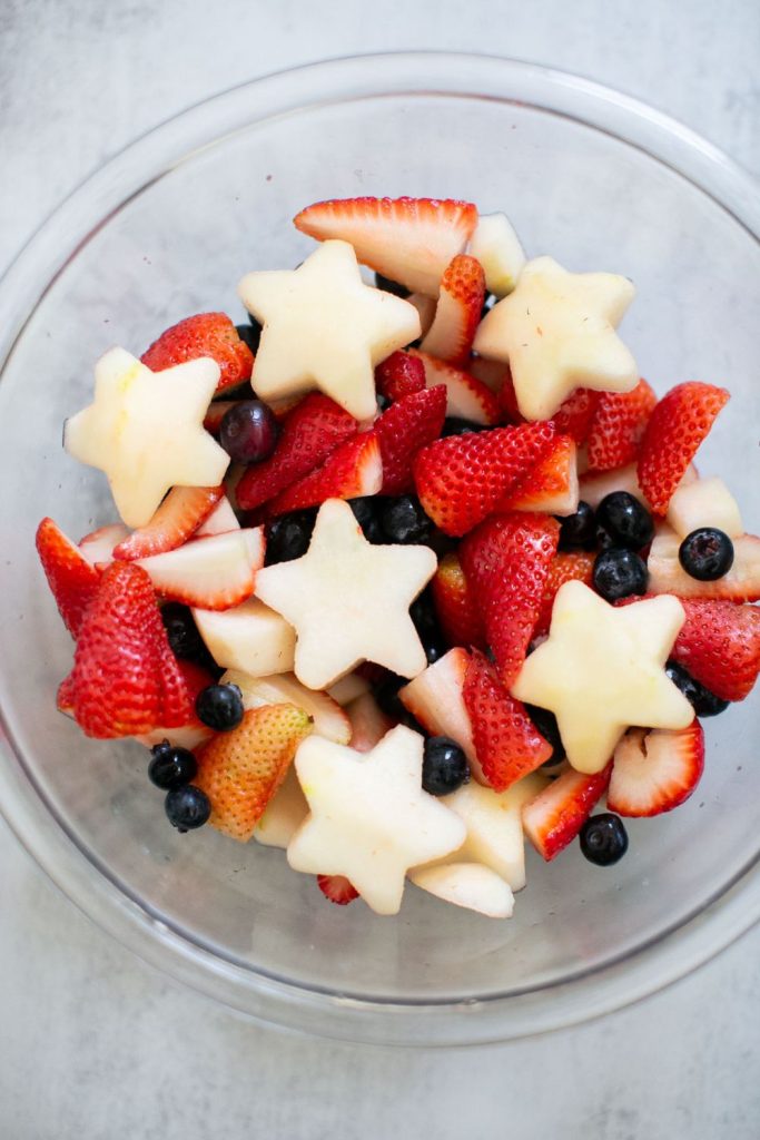 patriotic red white and blue fruit salad in a bowl.