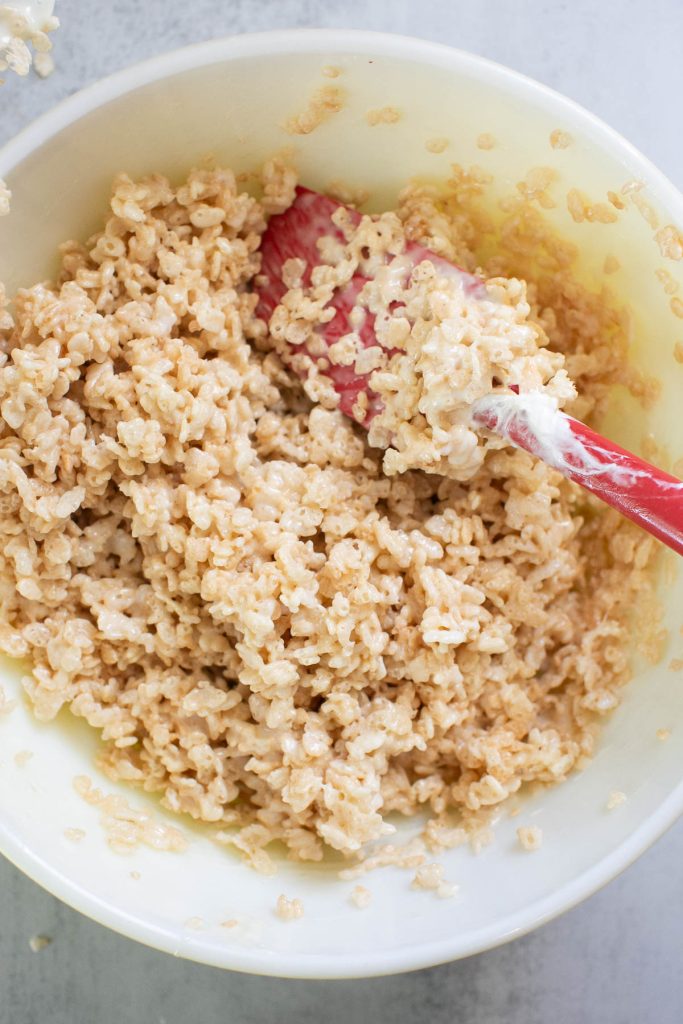 rice crispie cereal in a large bowl being mixed with cereal
