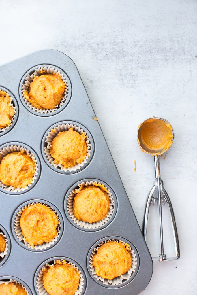 pumpkin muffin batter mixed together and placed in muffin tins.