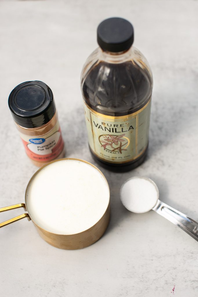 vanilla, pumpkin pie spice, heavy whipping cream and sugar on a table