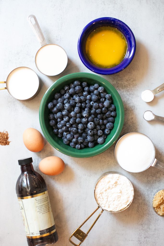 ingredients for sourdough discard blueberry muffins with blueberries with milk, baking powder, melted butter, discard, flour, sugar, eggs, vanilla, brown sugar, and salt