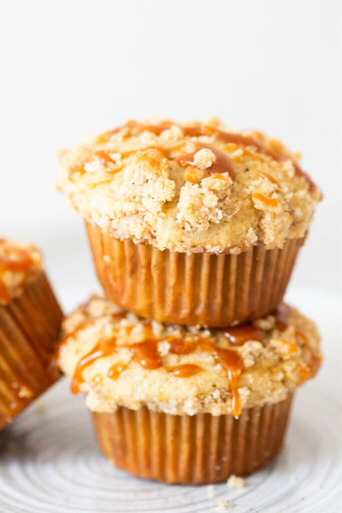 caramel apple muffins with crumb topping and caramel drizzled on top