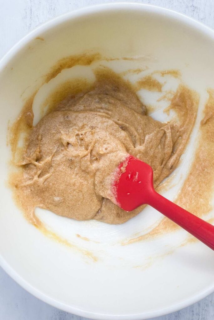 Browned butter sugar mixture combined with egg, vanilla and sourdough discard in a bowl.