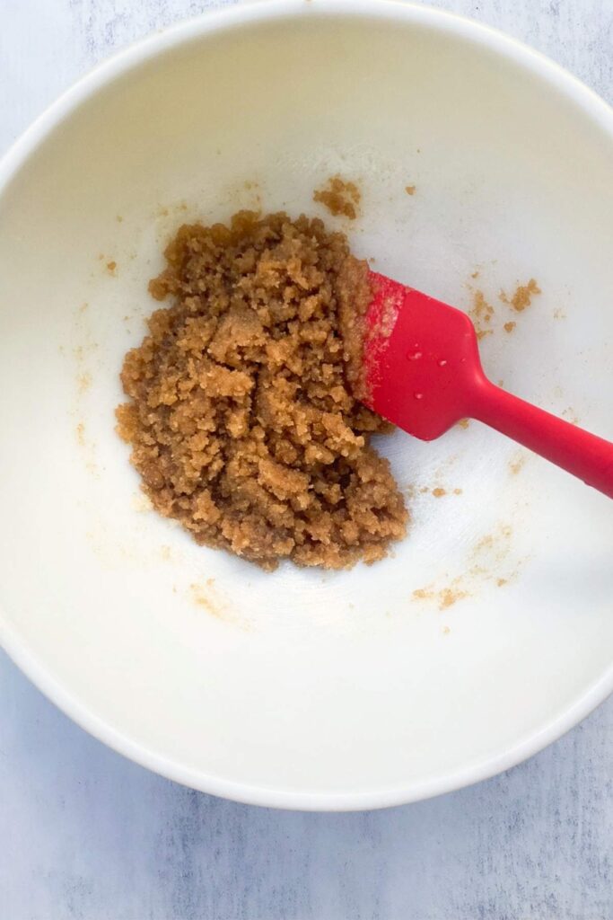 Browned butter combined with brown sugar and white sugar in a large bowl.