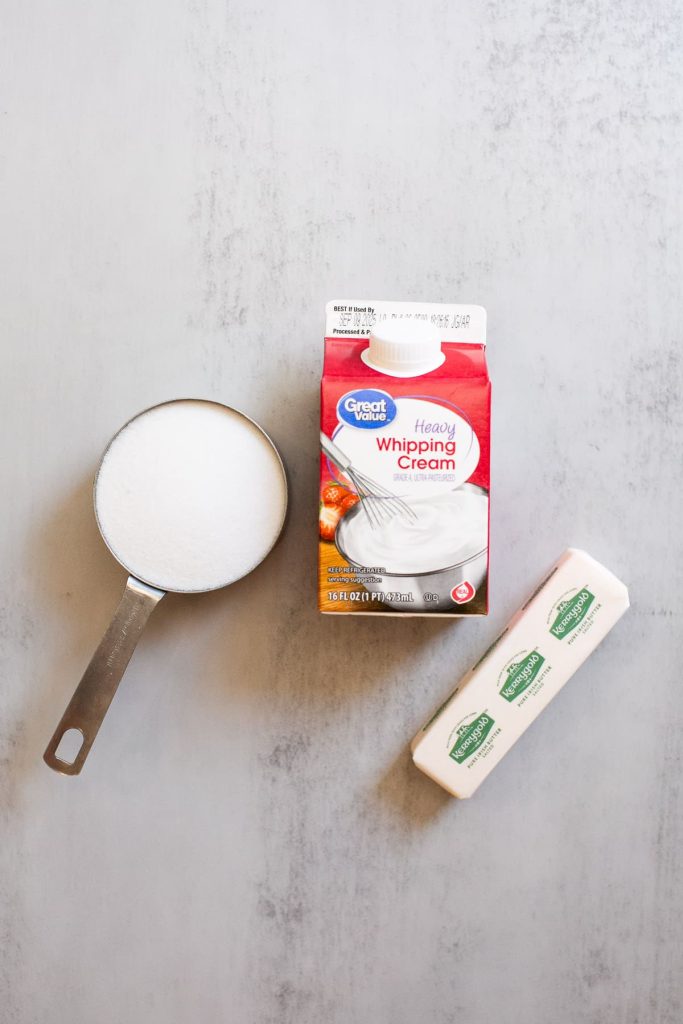 three ingredient caramel ingredients on a table: sugar, heavy whipping cream, butter