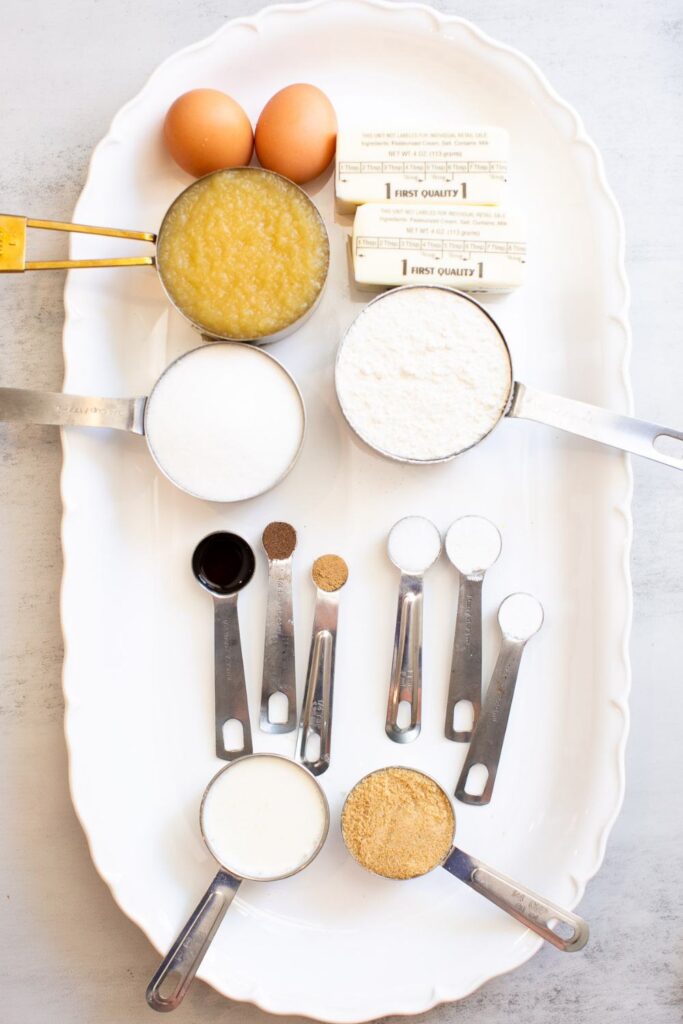 ingredients for caramel apple muffins: applesauce, eggs, butter, flour, sugar, nutmeg, vanilla extract, baking soda, salt, brown sugar