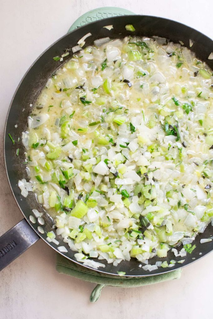 celery and onion being cooked in a pan with butter