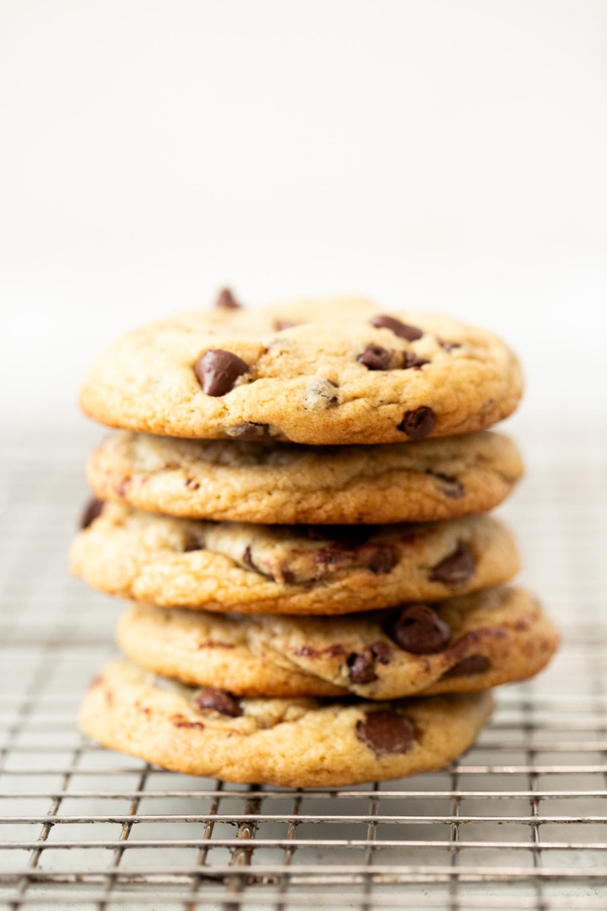 A stack of brown butter sourdough discard chocolate chip cookies sitting on a baking tray.