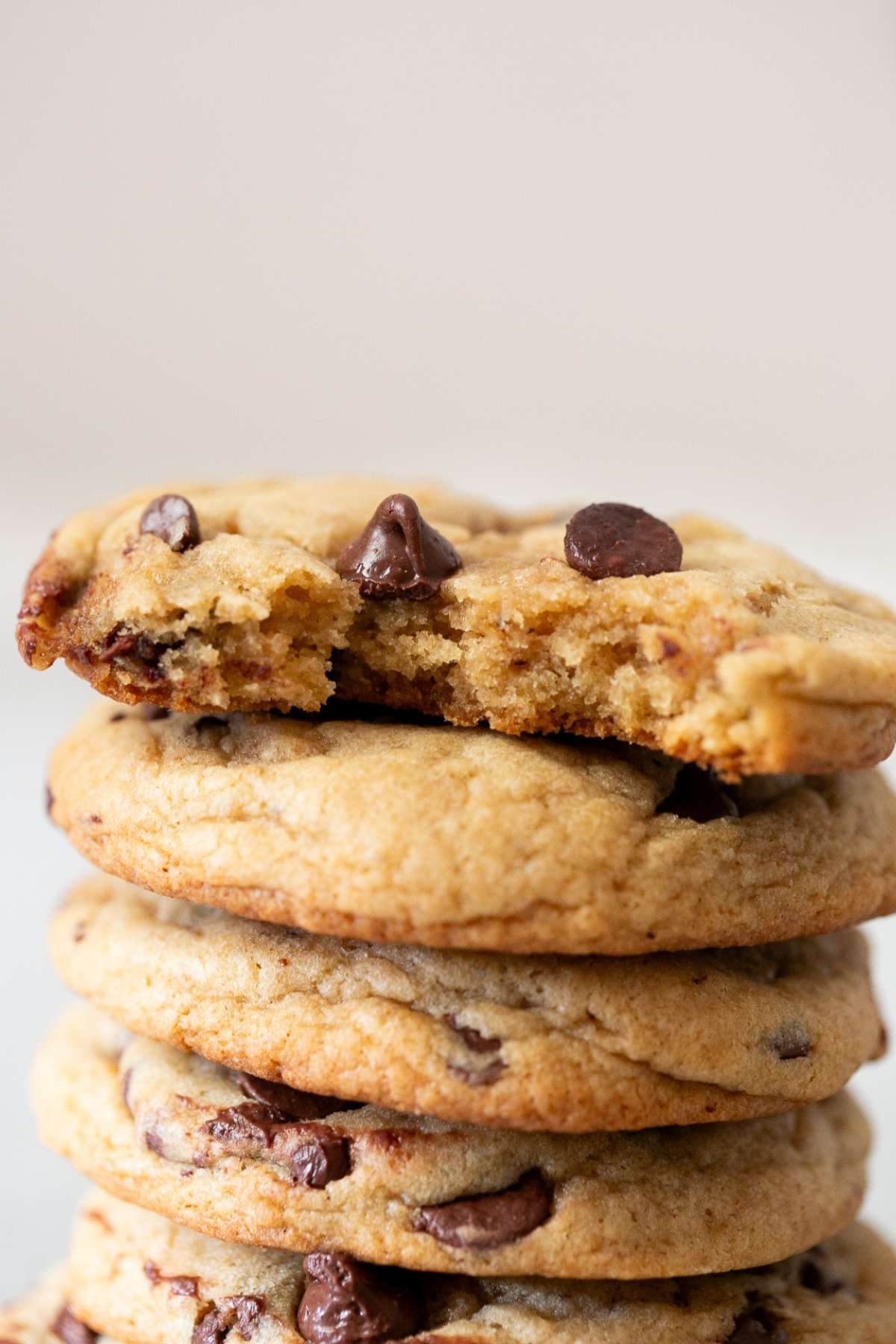 A stack of thick sourdough discard browned butter chocolate chip cookies on a table.