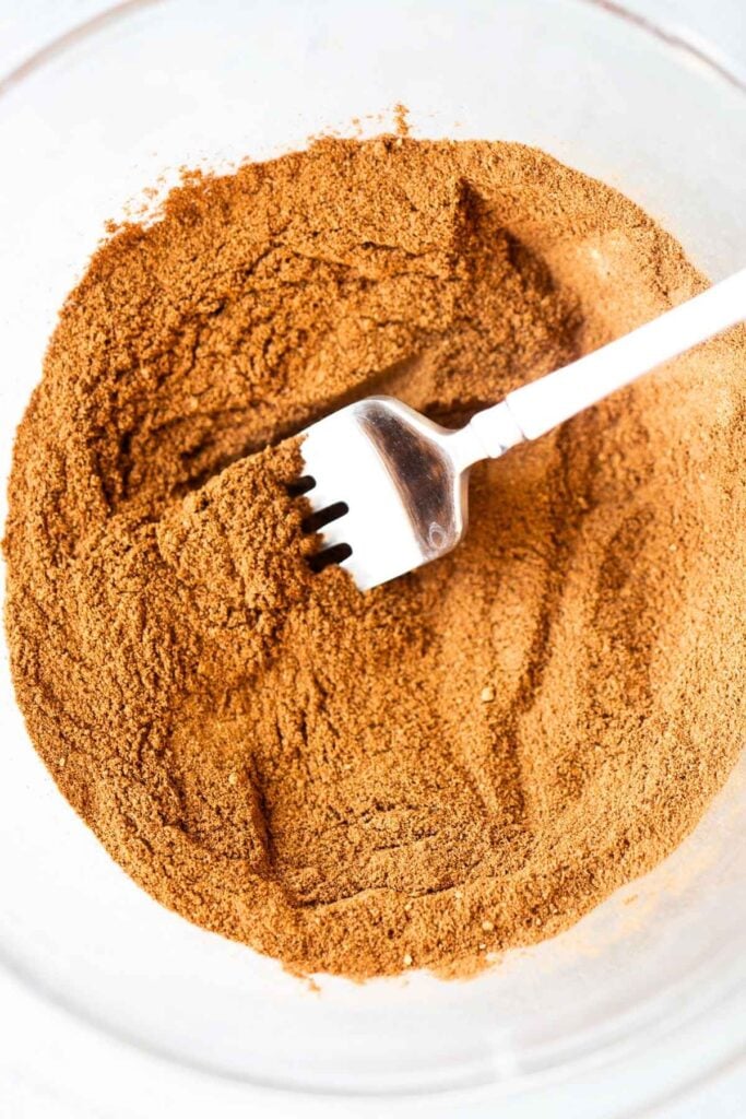 Ingredients for homemade pumpkin pie spice being mixed in a bowl.
