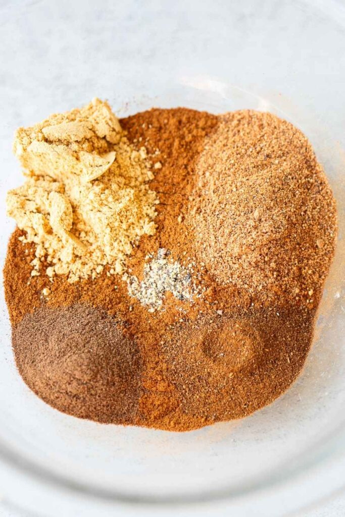 ingredients for pumpkin pie spice in a bowl: cinnamon, nutmeg, black pepper, allspice and clove