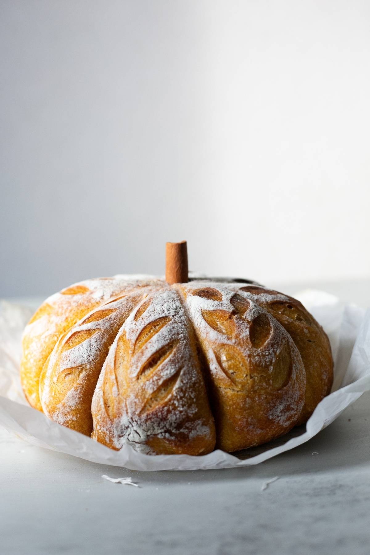 A pumpkin shaped sourdough bread loaf sitting on a table. 