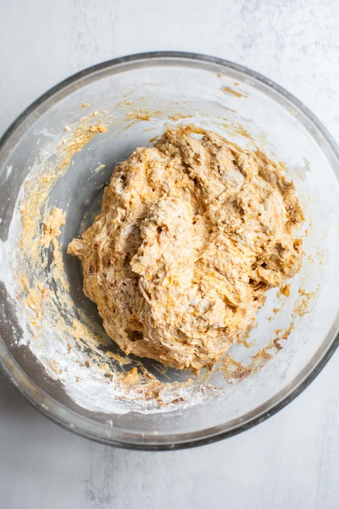 ingredients for sourdough pumpkin spice dough mixed together in a bowl 