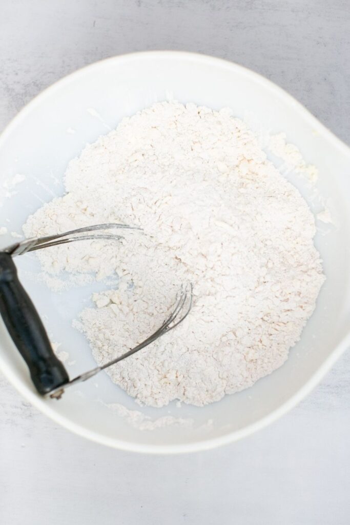 dry ingredients for pumpkin scones in a bowl: flour, baking powder, salt, pumpkin spice, and salt