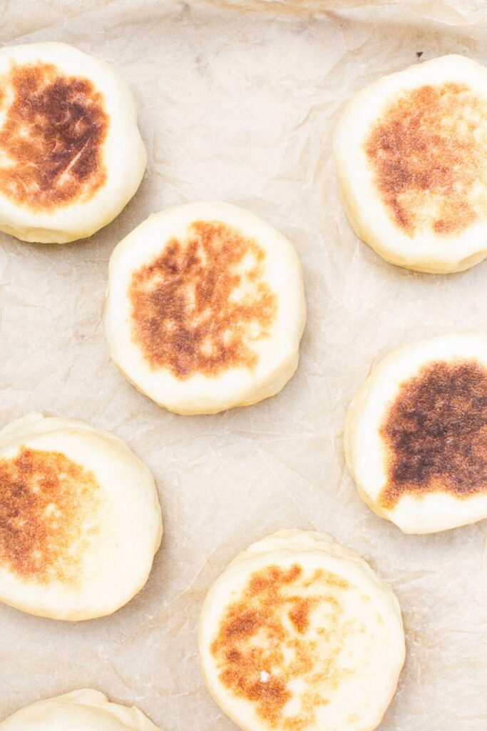 overnight sourdough English muffins on parchment paper