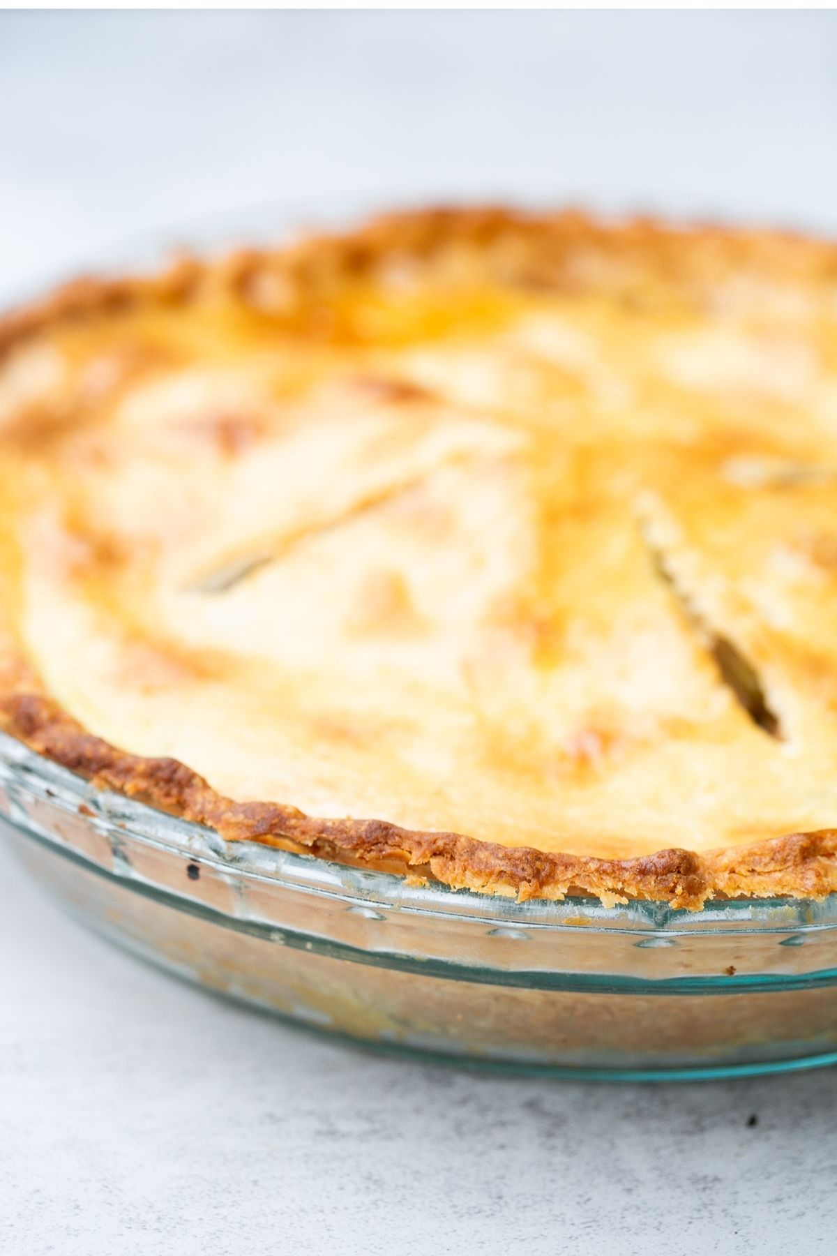 An apple pie with homemade crust sitting on a counter top.