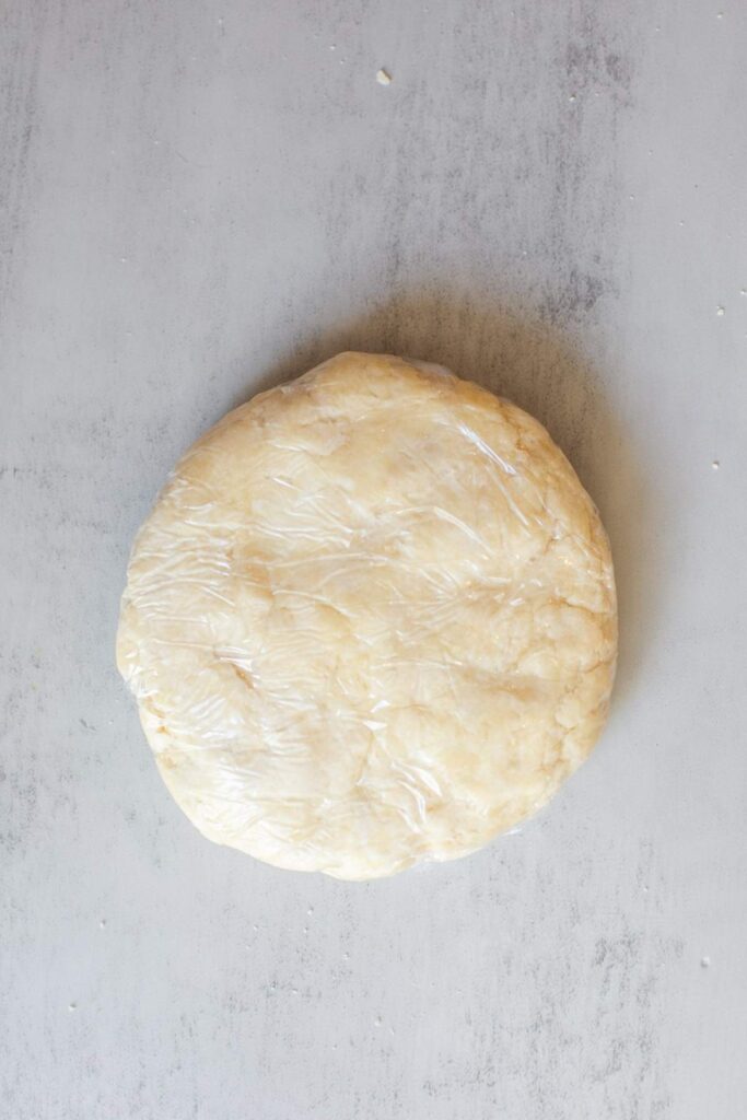 Pie crust dough wrapped in plastic wrap.