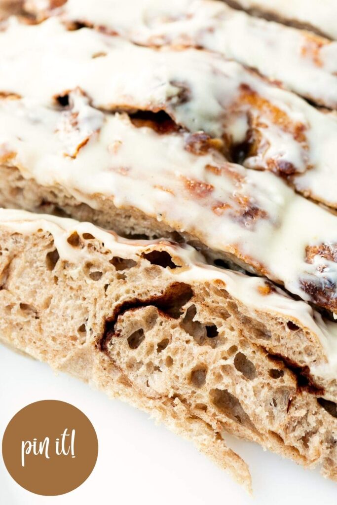 sourdough cinnamon roll focaccia sliced with cream cheese frosting
