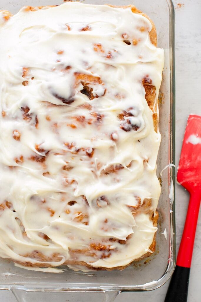 sourdough cinnamon roll focaccia in a pan with cream cheese frosting