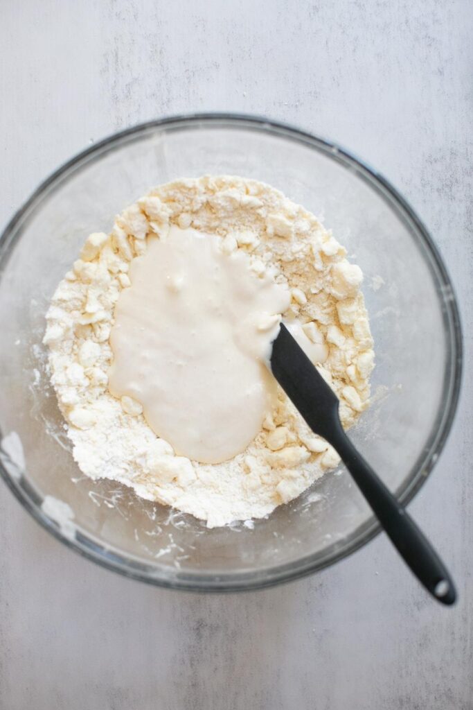 sourdough discard poured into flour mixture for pie dough