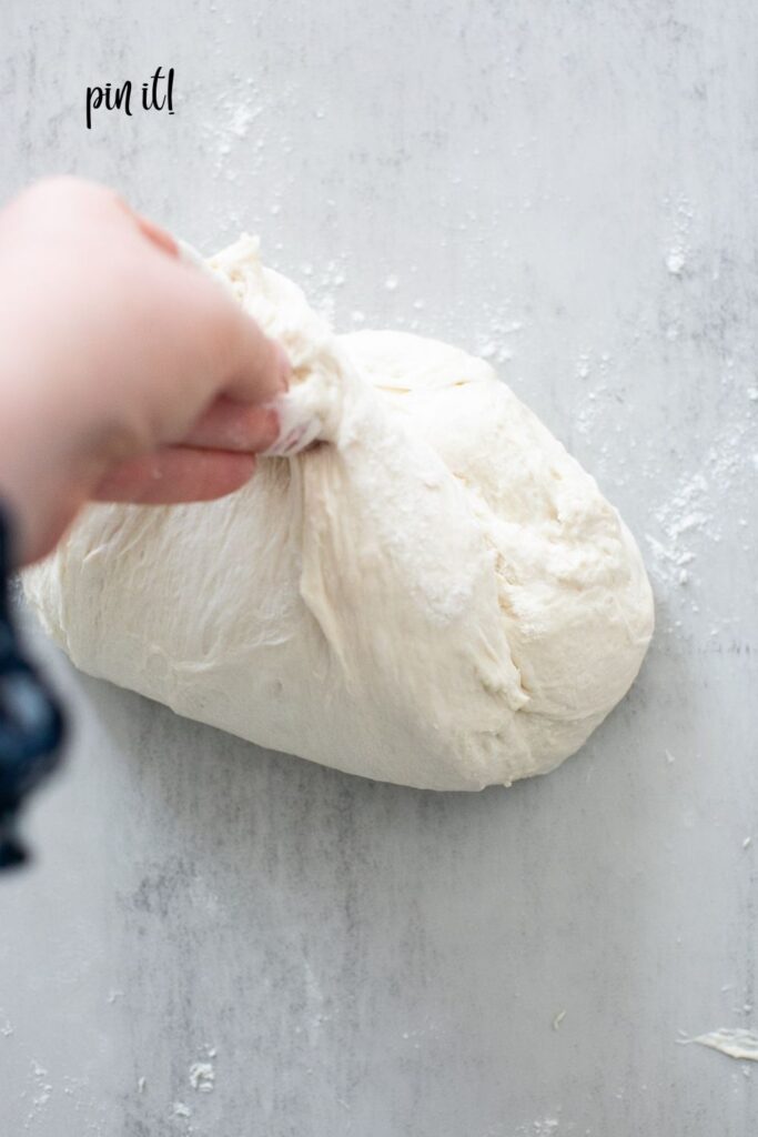 unloaf sourdough bread being shaped into a round boule