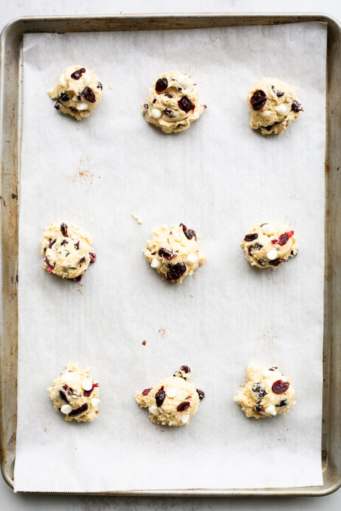 sourdough cranberry white chocolate chip cookie dough balls on a baking sheet