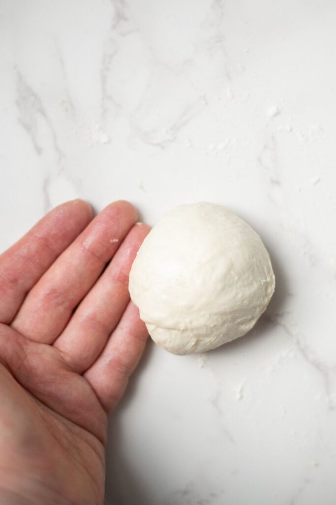 sourdough croissant bread roll dough being shaped into a roll