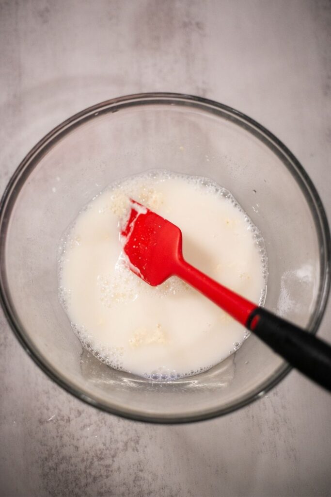sourdough starter and water being mixed togehter in ab owl