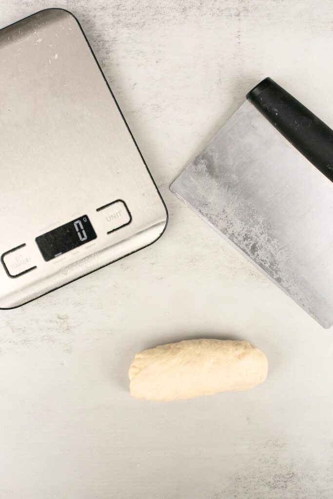 sourdough pretzel dough being weighed on a kitchen scale