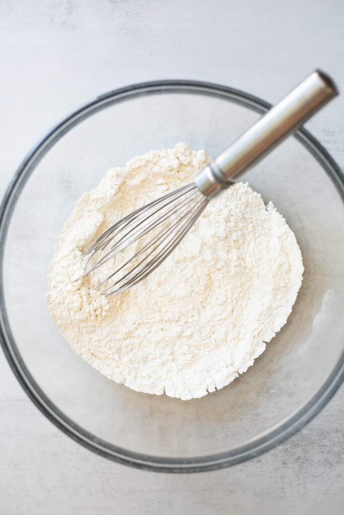 dry ingredients for sourdough banana muffins mixed with a whisk in a large bowl.