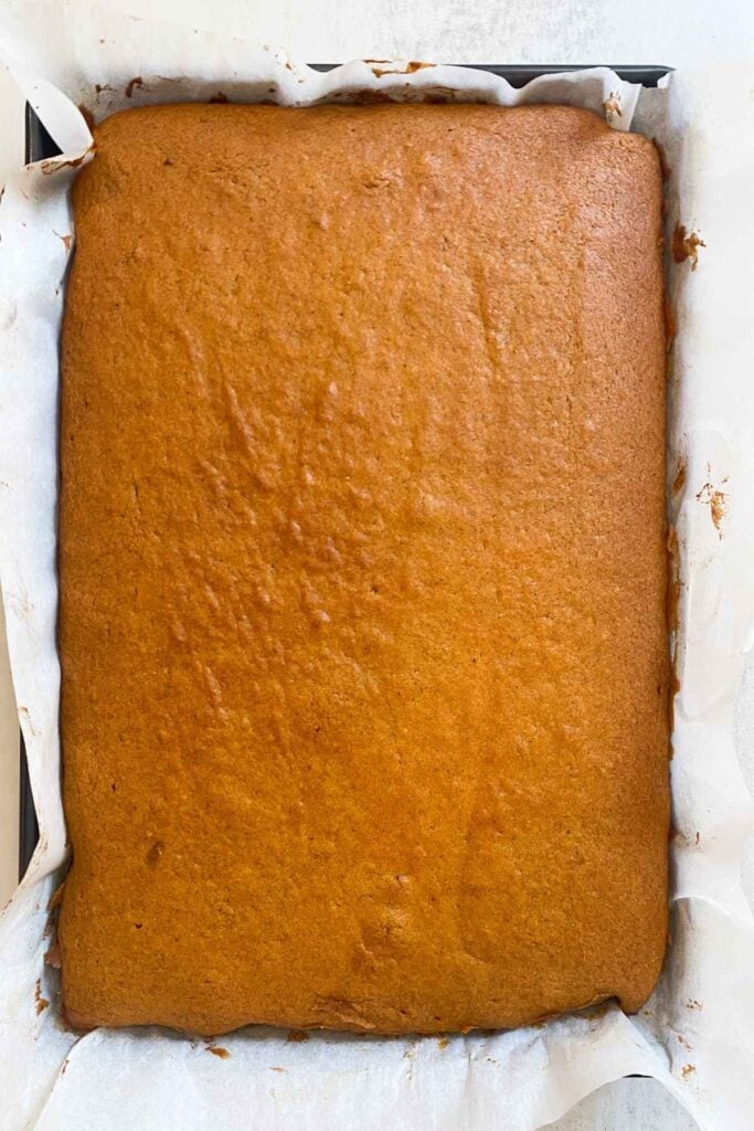 sourdough discard pumpkin bar batter in a jelly roll pan on a table.