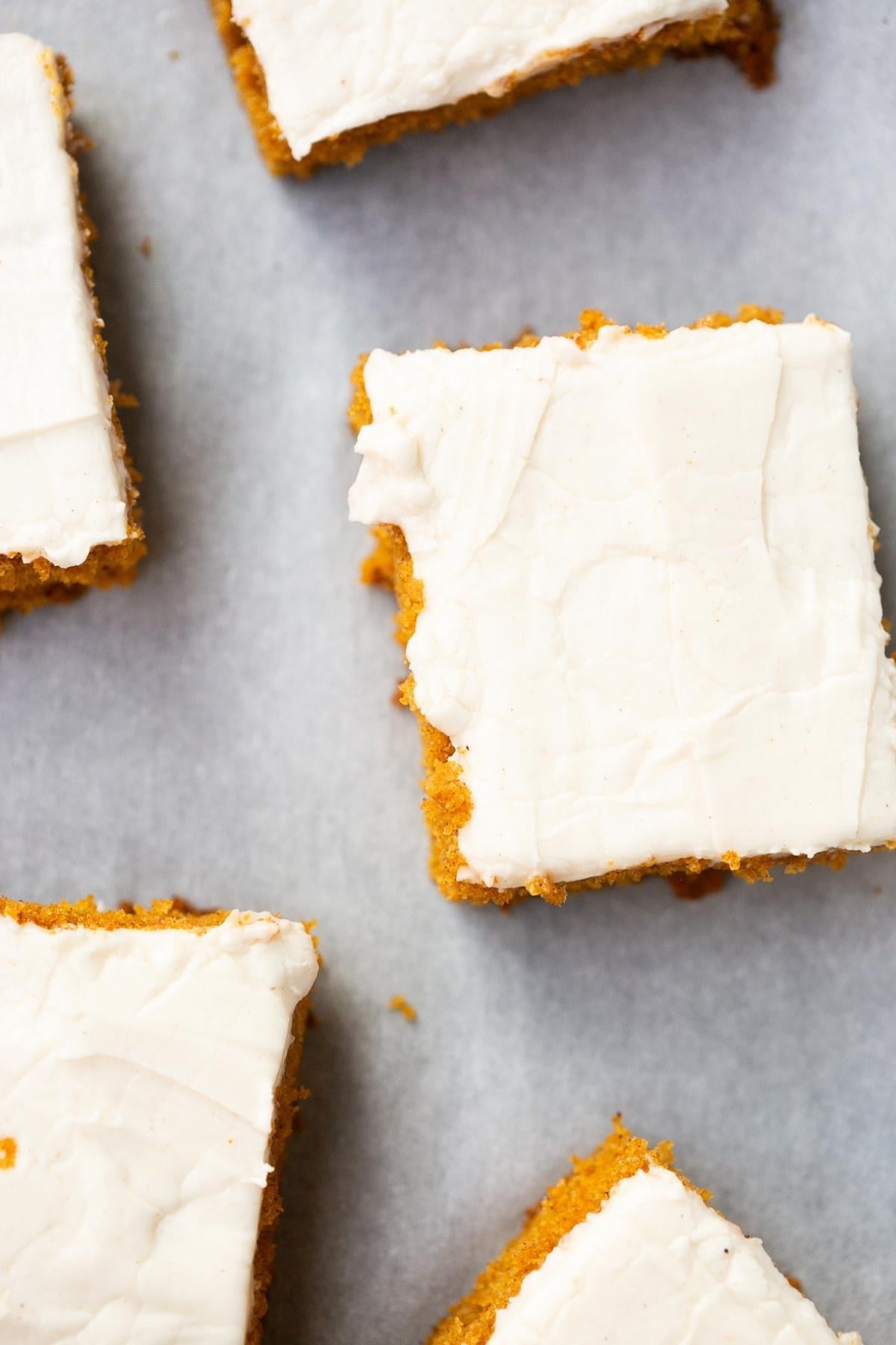 sourdough discard pumpkin bars with cream cheese frosting on a tray.