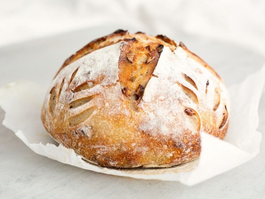 Sourdough maple pecan bread loaf with cinnamon swirl on a table.