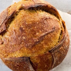 A loaf of artisan sourdough pumpkin bread on a table.