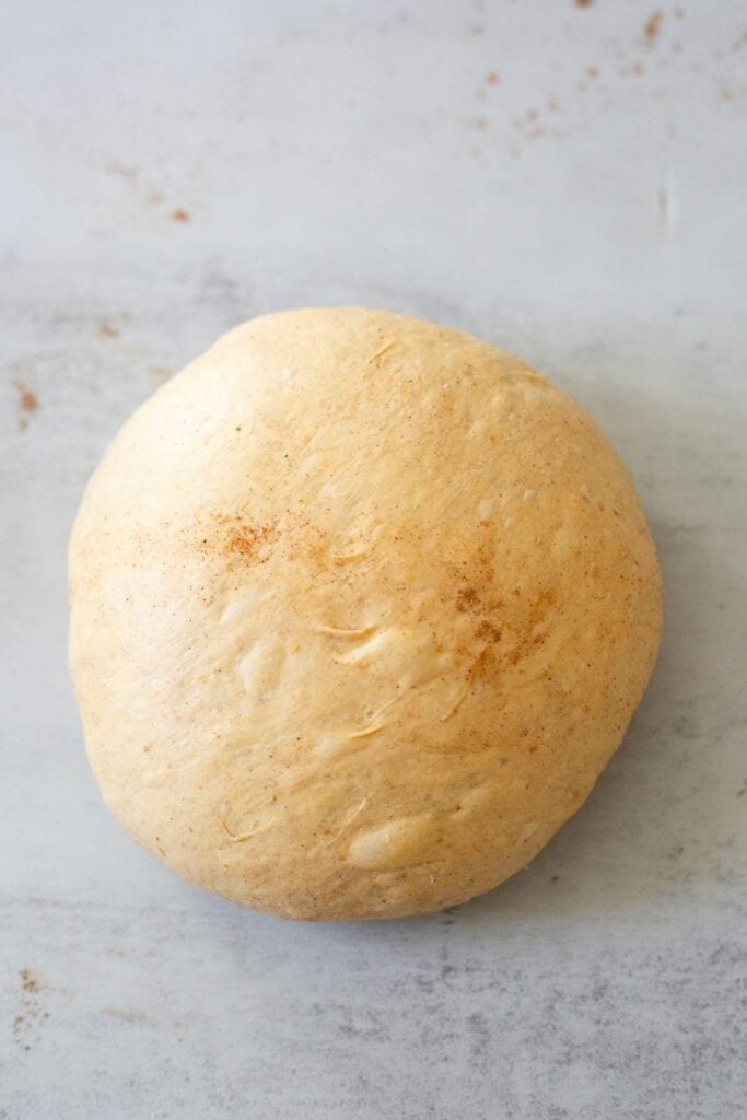 A loaf of artisan sourdough pumpkin bread dough on a counter.