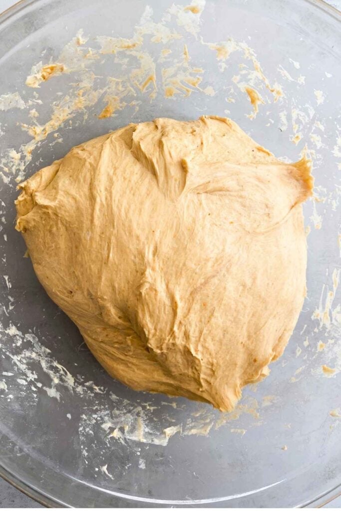 Sourdough pumpkin bread in a clear bowl after it is done fermenting.
